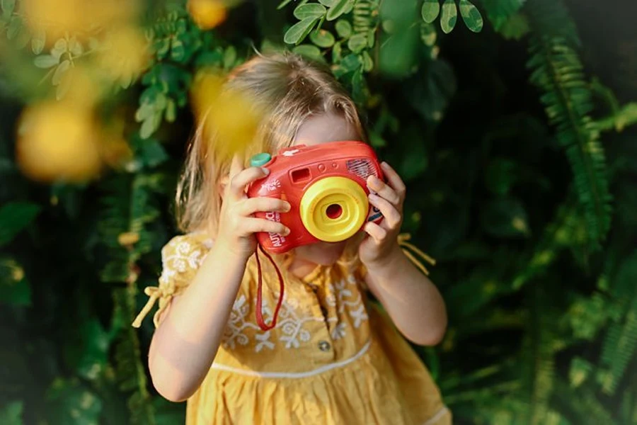 ein kleines Mädchen, das eine Kinderkamera benutzt