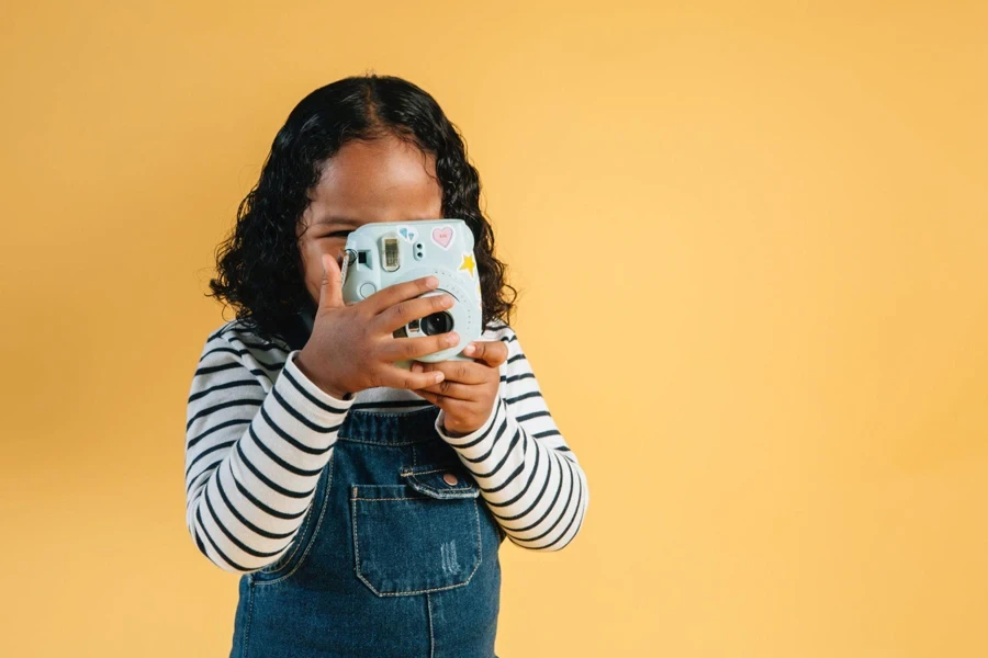 une petite fille utilisant l'appareil photo des enfants