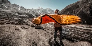 A man carrying a camping sleeping bag