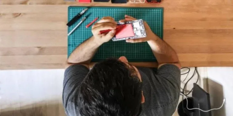 A man fixing a device with a phone repair tool