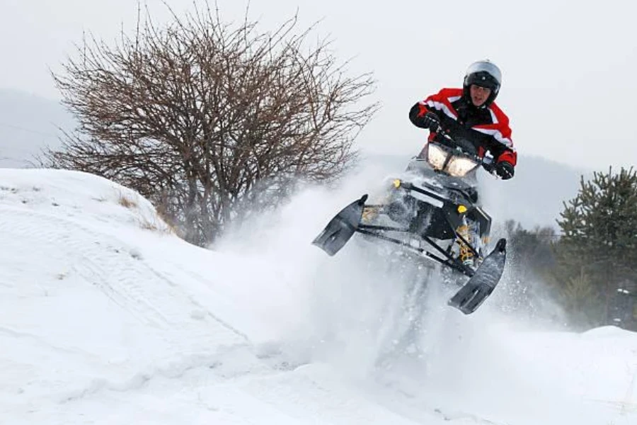 Un hombre felizmente montando una moto de nieve.