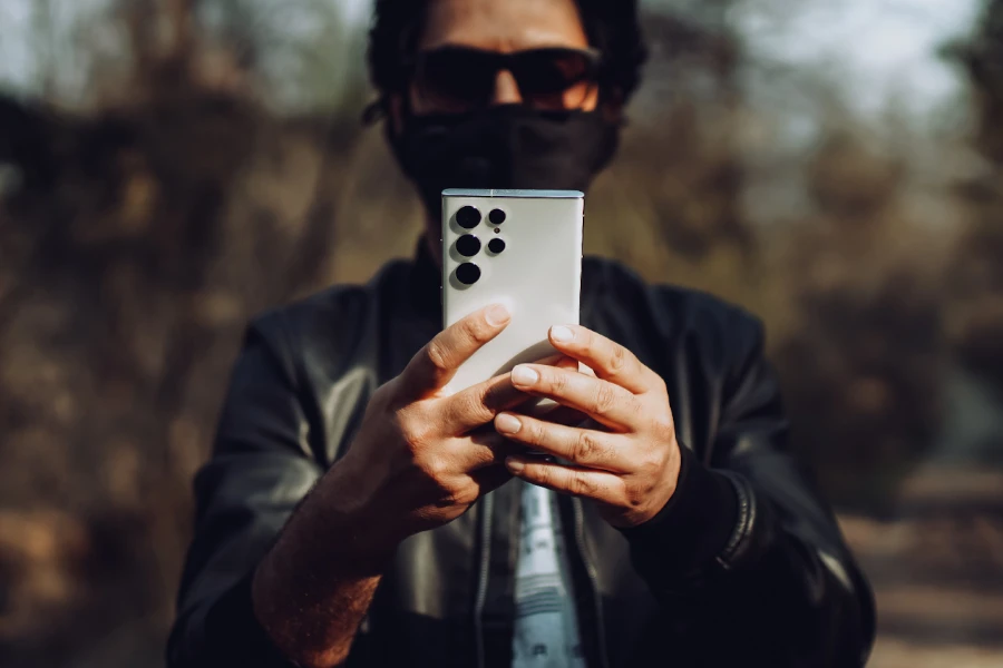 A man holding a white phone with five camera sensors