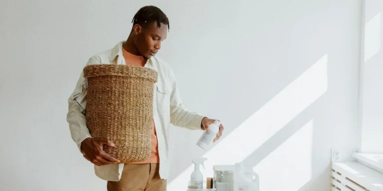 Un homme tenant un panier à linge en osier