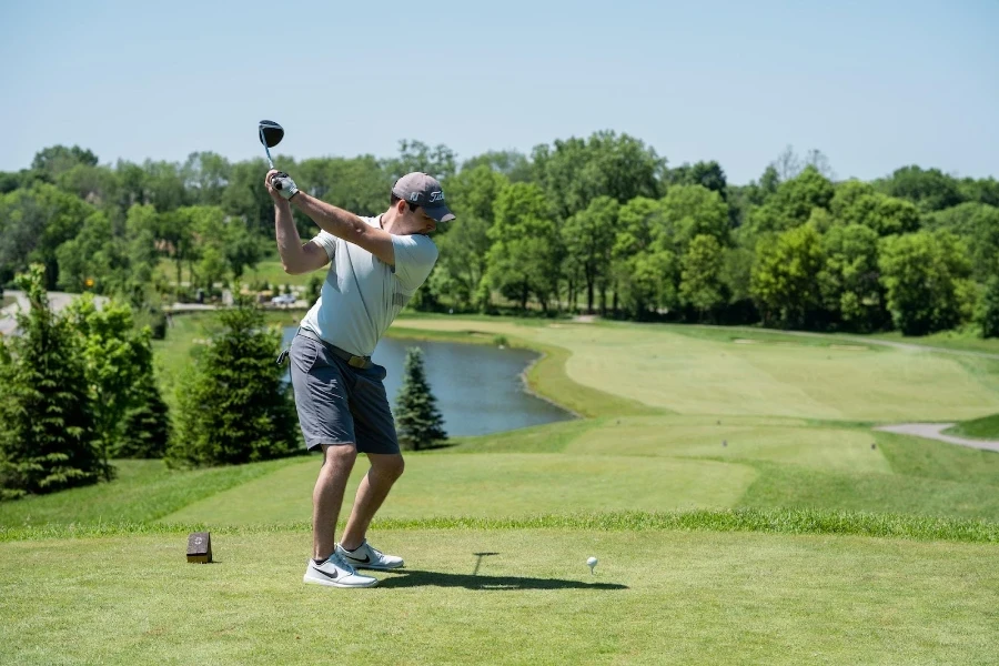 A man playing golf in branded golf shoes