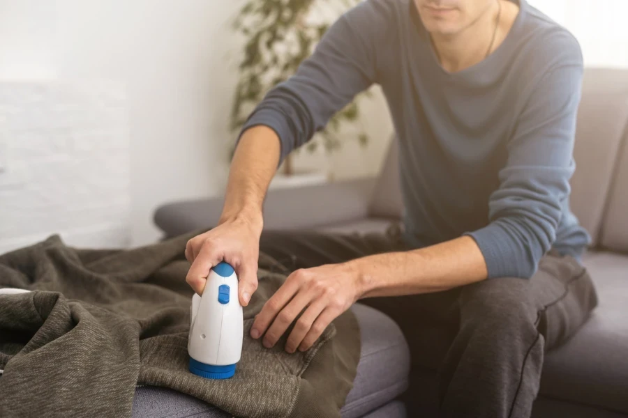 A man removing the lint from the sweater