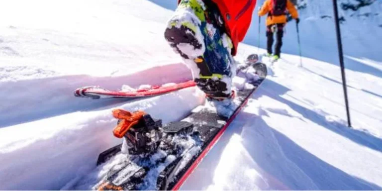 A man using a ski binding covered in snow