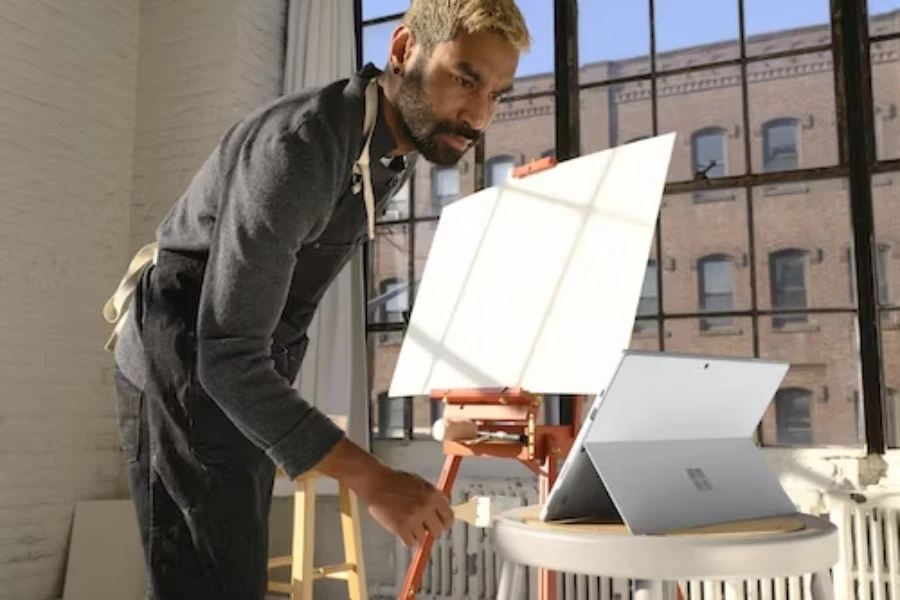 A middle-aged man using a tablet on a foldable stand