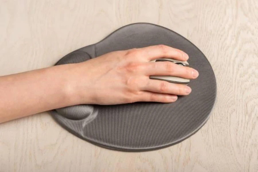 A person gliding a mouse along a mouse pad