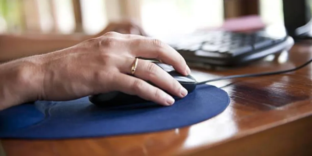 A person navigating a mouse on a mouse pad