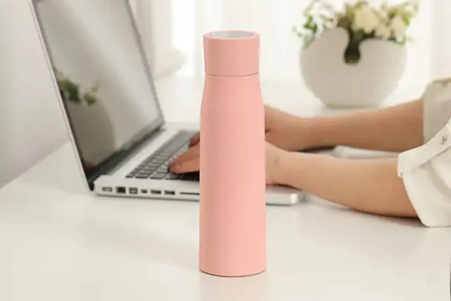 A pink water bottle on the desk