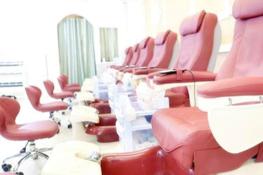 A row of piped pedicure chairs in a nail salon