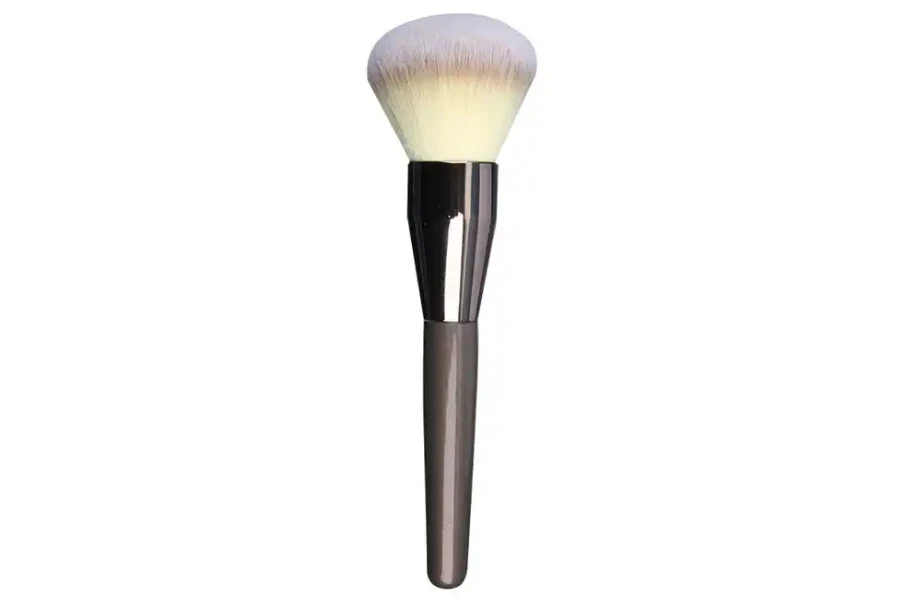 A single powder brush on a white background