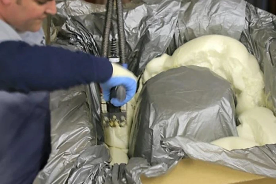 A specialist using an automated packaging system to mold foam-in-place