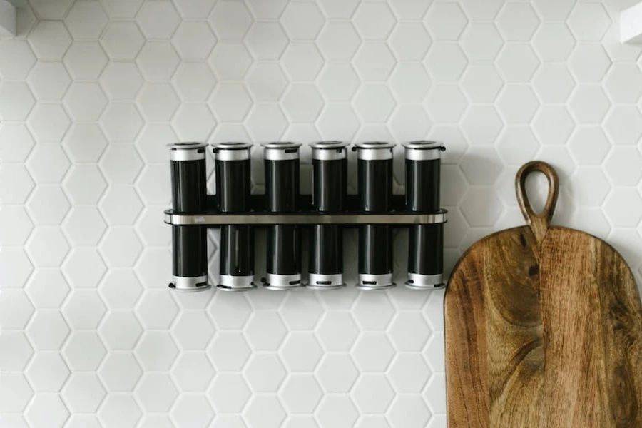 A spice rack hung on a white kitchen wall