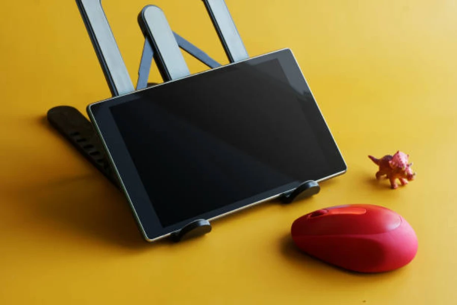 Un tablet su un supporto regolabile su sfondo giallo