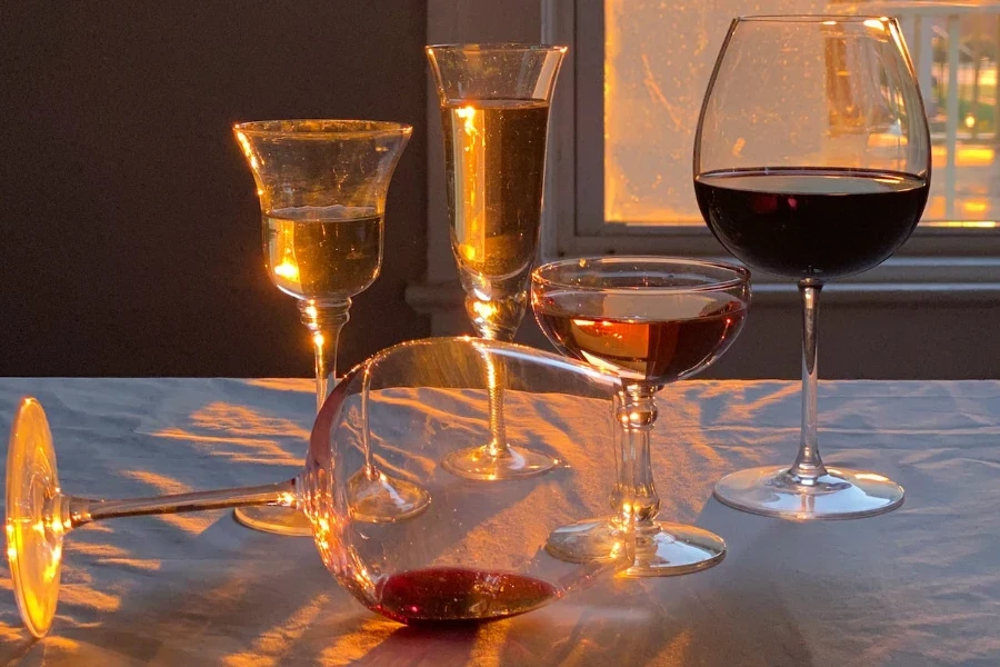 a variety of glasses filled with alcoholic drinks in a sunny room