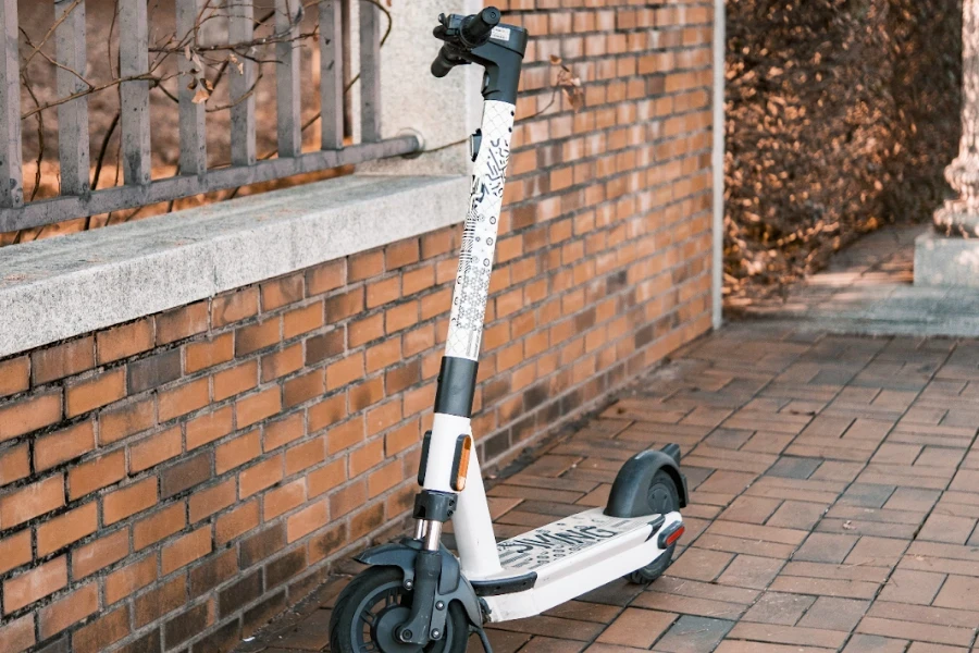 Un scooter blanc garé près d’un mur de briques