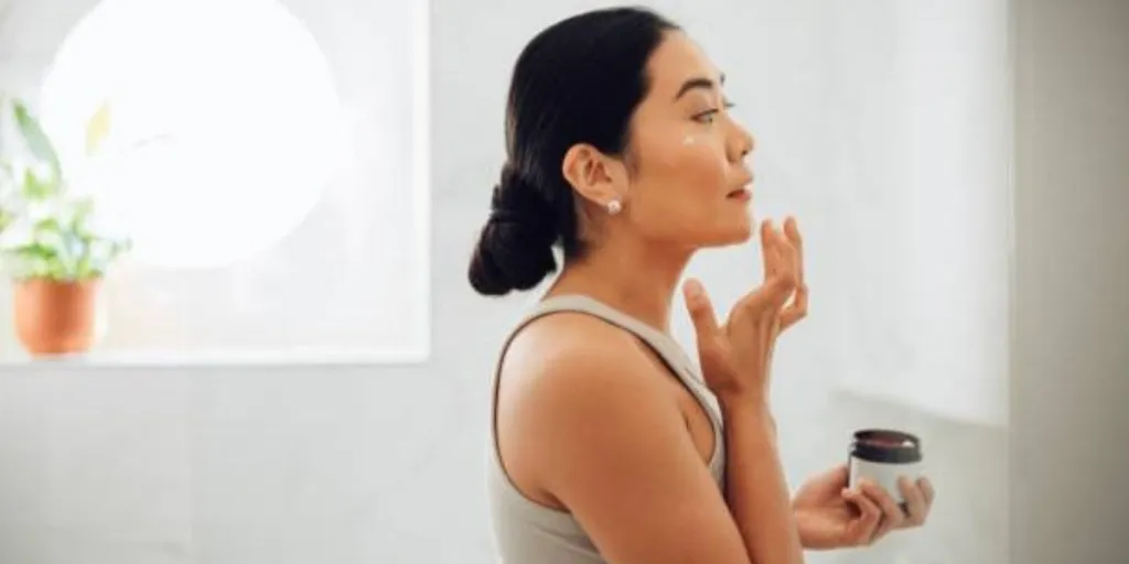 A woman applying a skincare product to her T-zone