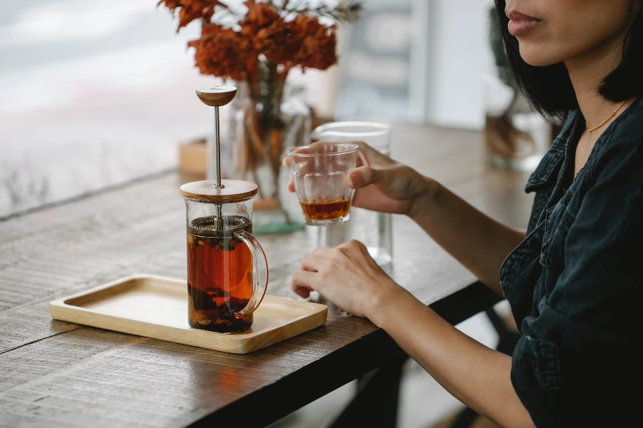 A woman enjoying herbal tea in glass cup