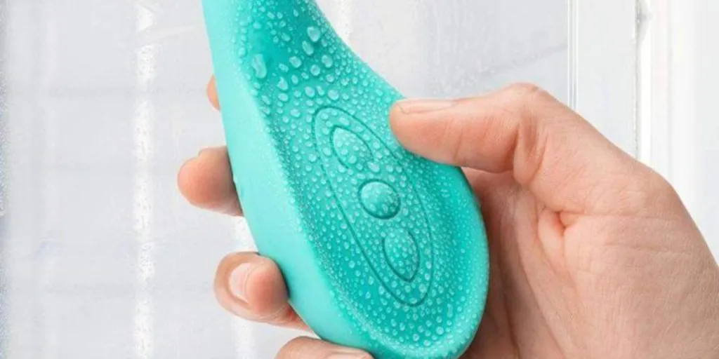 A woman holding a breast massager with water droplets on it