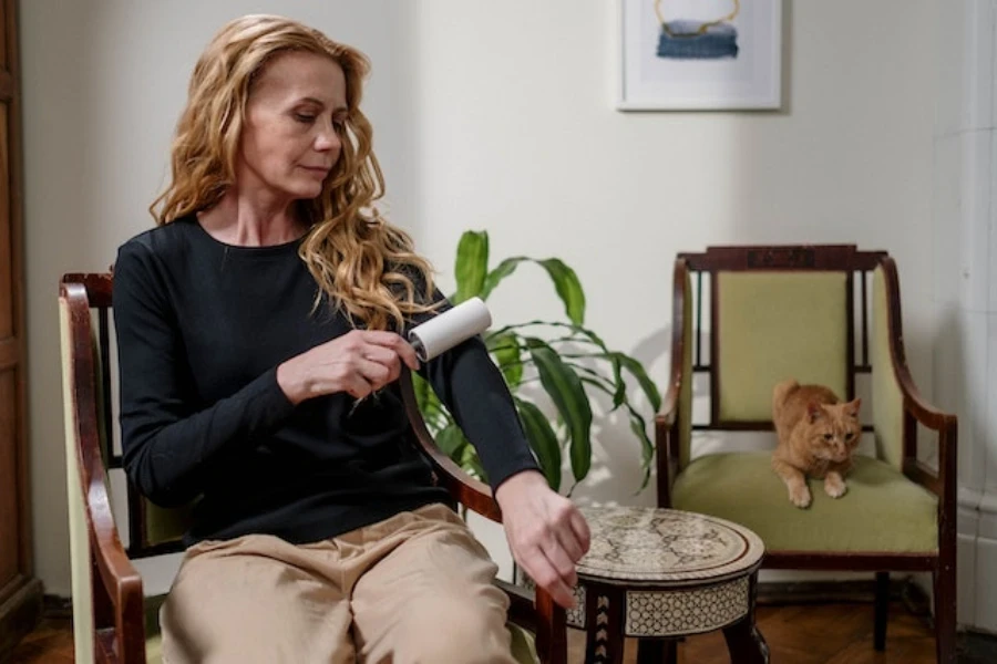 A woman using a lint roller on her clothes