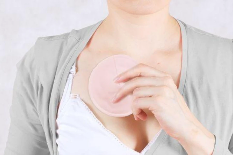 A young woman holding an absorbent nursing pad