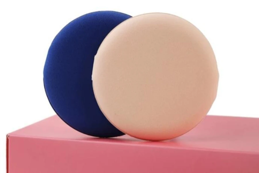 Air cushion puffs displayed on a pink box on a white background