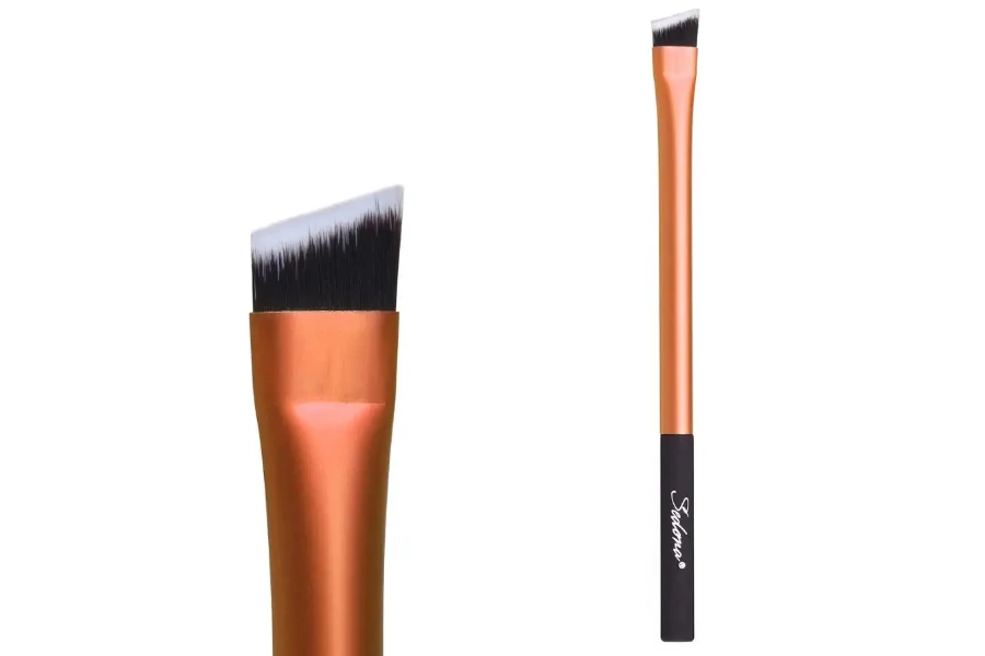 An angled cheek brush with a bronze handle