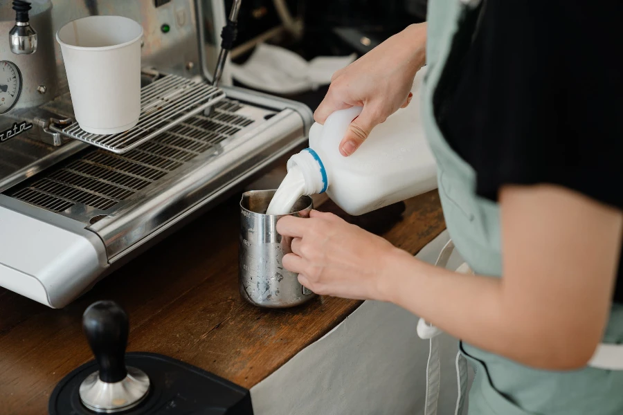 Barista pouring milk from a pitcher