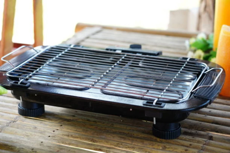 black electric grill for camping sitting on wooden table outdoors
