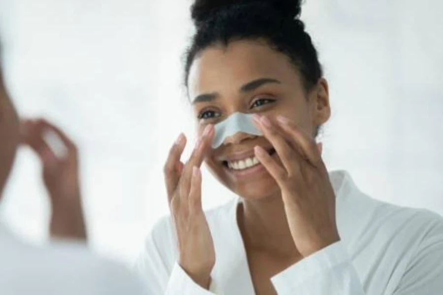 Mujer negra sonriendo mientras se aplica una tira nasal