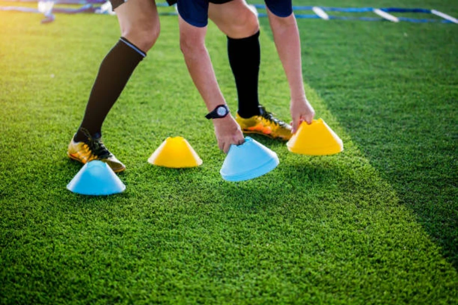 Conos azules y amarillos para entrenamiento de fútbol en el campo