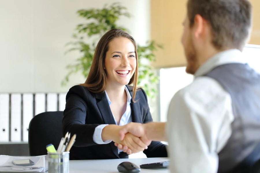 businesswoman shaking hands with a satisfied client