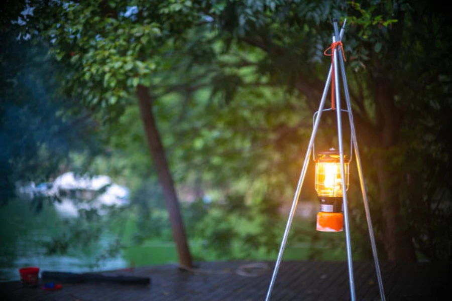 Camping lantern hung up next to campsite in forest