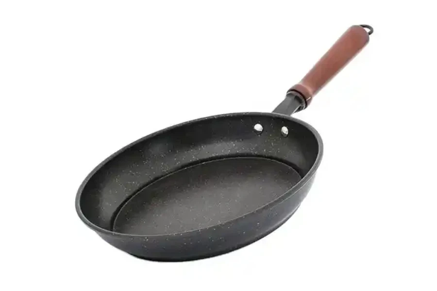 Cast carbon steel sauté skillet with wooden handle