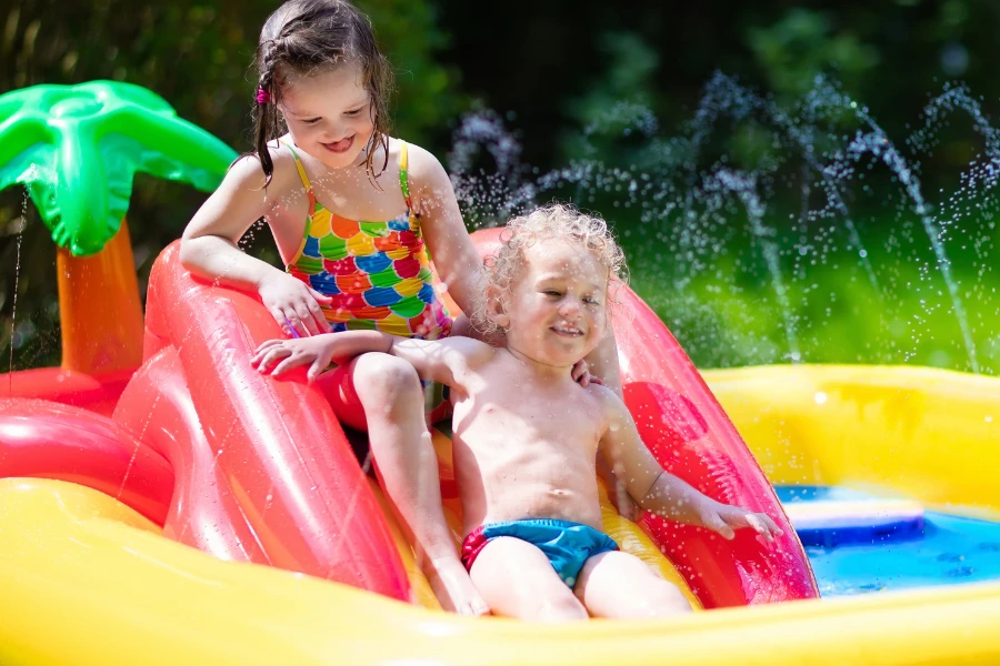 Children playing on a small slide in an inflatable pool