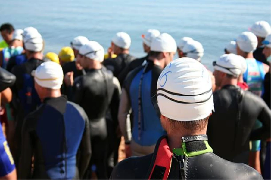 Collection of people wearing white swimming caps outdoors