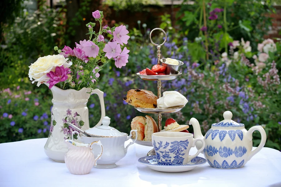 delicate English traditional afternoon tea set in the garden