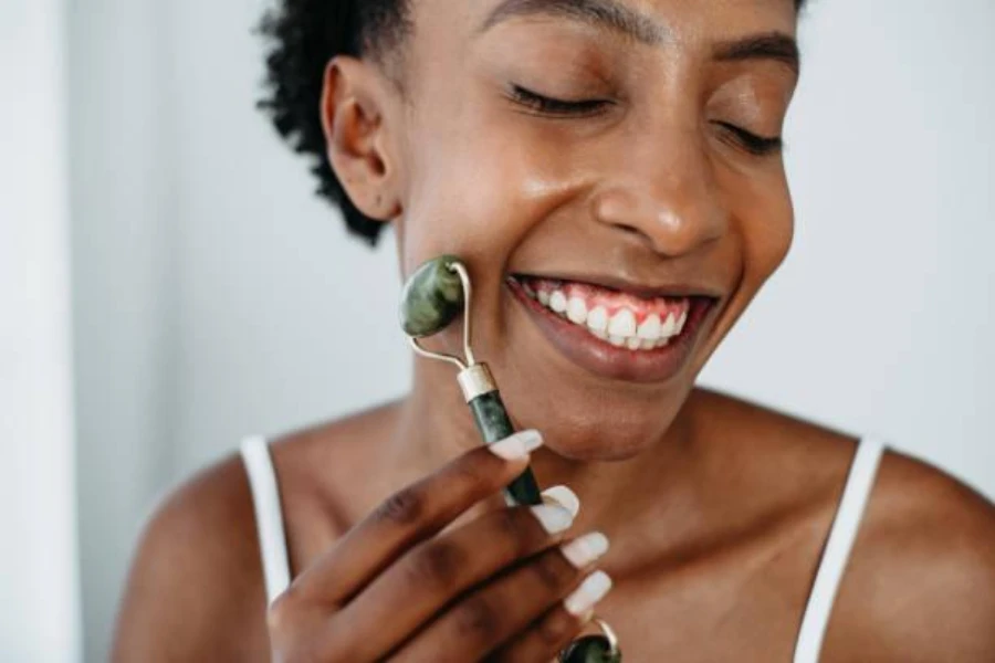 Female in bathroom smiling while using authentic jade roller