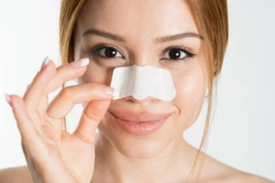 Female taking off easy-to-remove nose strip while smiling