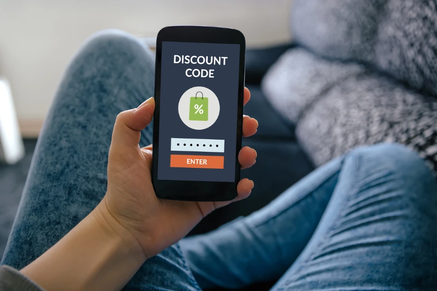 Girl holding a smartphone with discount code
