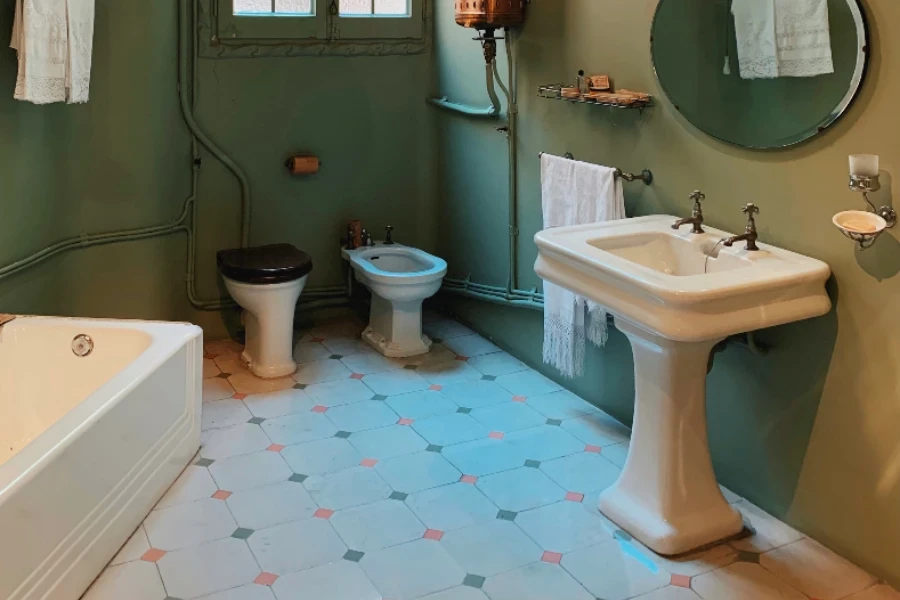 Bagno verde con lavabo tradizionale su colonna