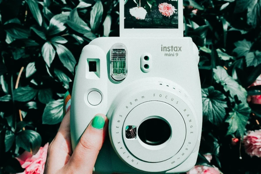 Green polaroid camera printing a picture of flowers