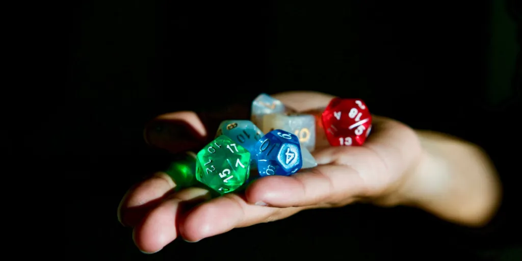 Hand holding different types of dice for games