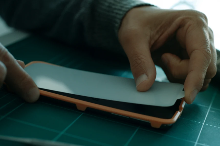 Hands applying a matte screen protector to a phone