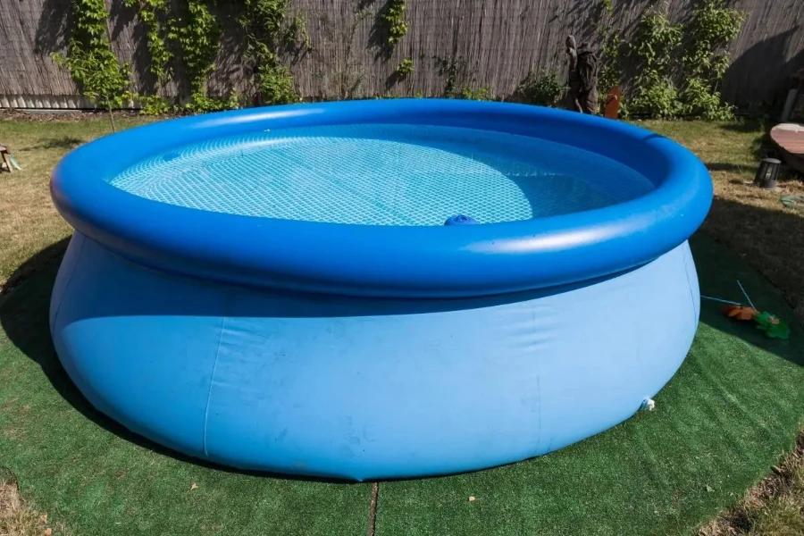Large blue inflatable pool filled with water in a backyard