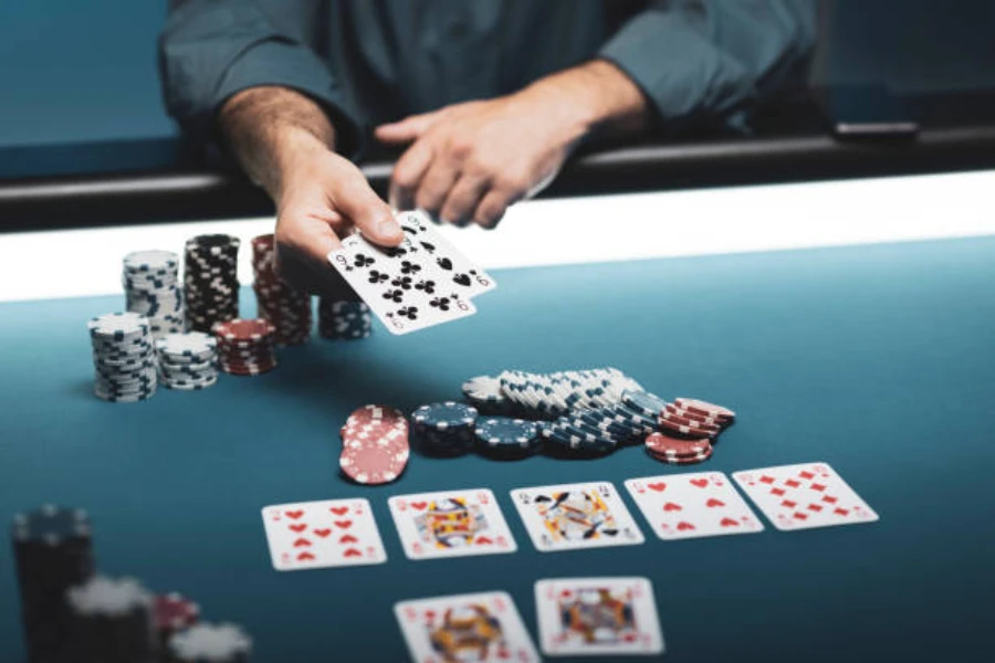 Man showing two of his cards during a poker game