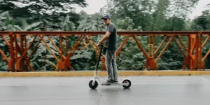 Man wearing a black shirt riding a scooter