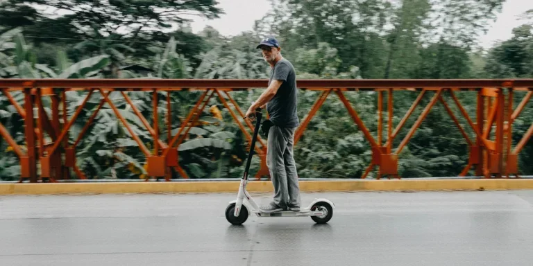 Man wearing a black shirt riding a scooter