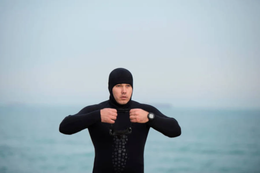Man wearing black cold water wetsuit with black hood